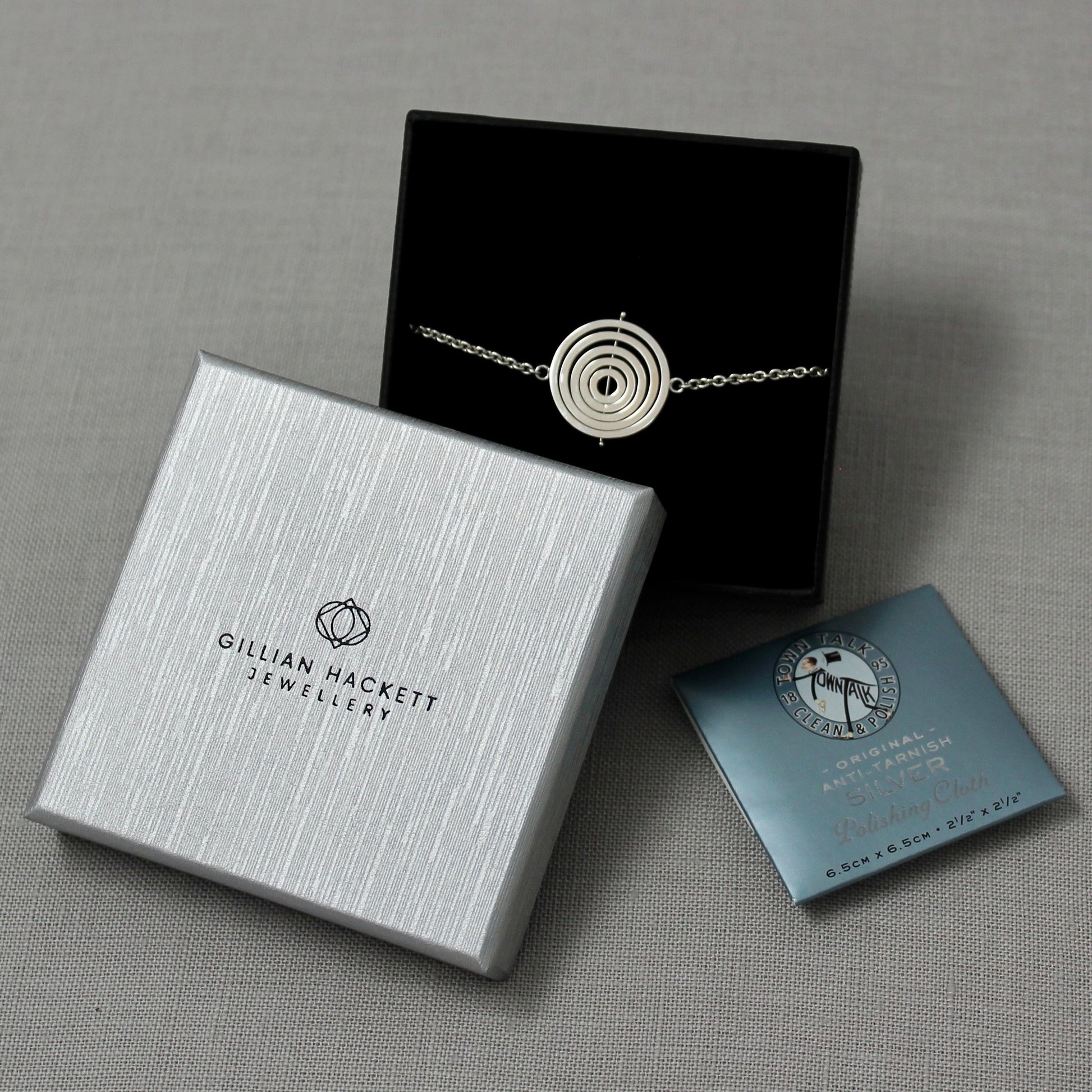 Handmade sterling silver kinetic bracelet in Gillian Hackett Jewellery luxury black gift box with logo on grey textured lid 