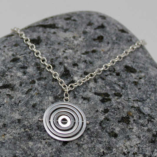 Sterling silver 1.5cm kinetic charm with concentric recycled square wire rings held by central pin, on dainty bracelet chain